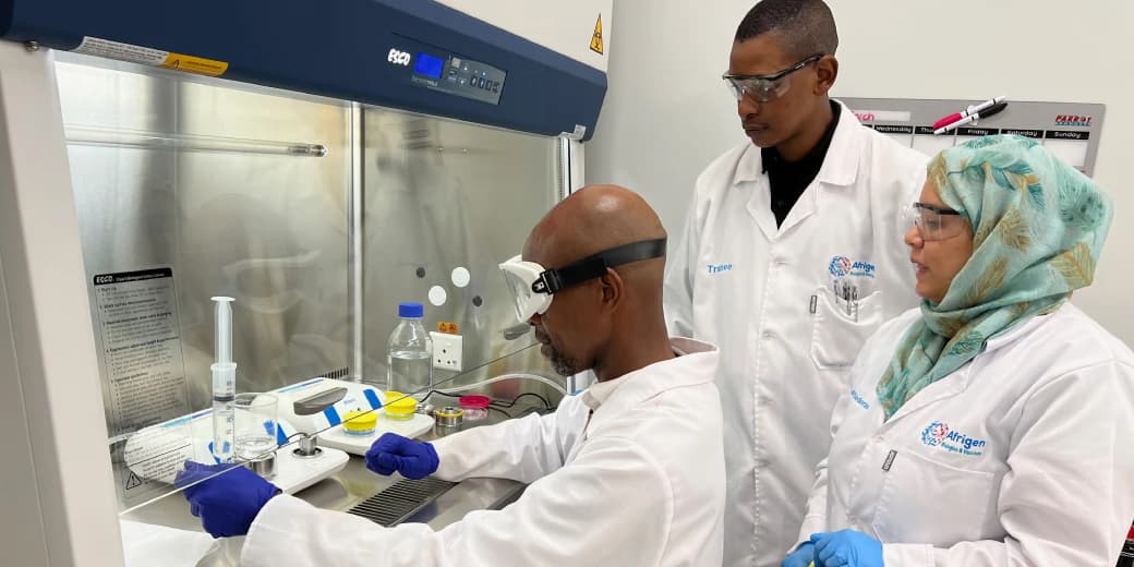 Scientists working with laboratory equipment at an African mRNA research facility.