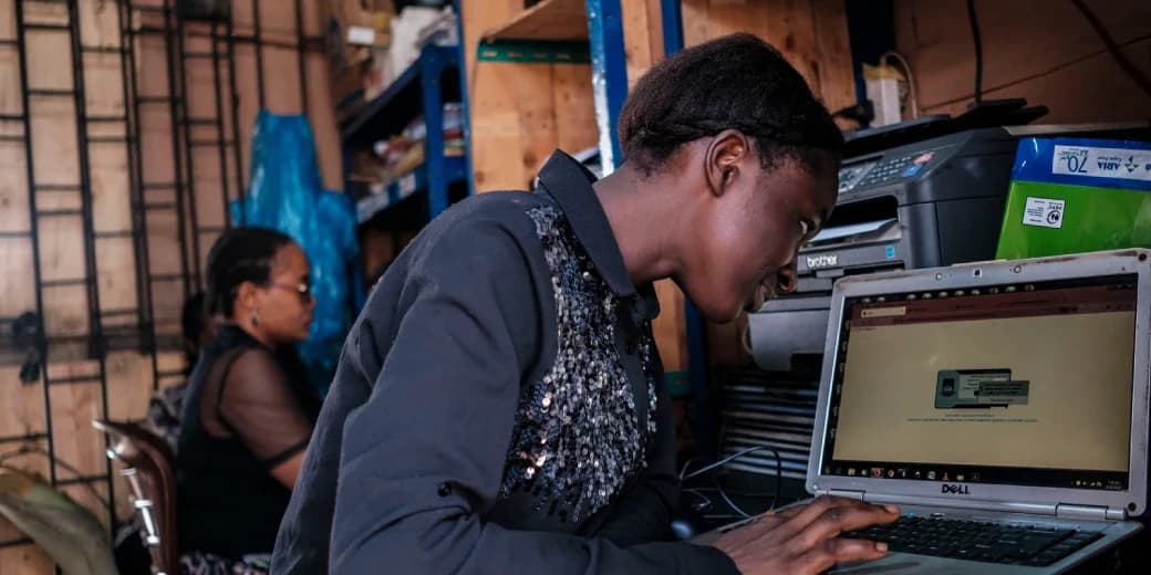 A customer using a laptop inside a Kenyan cyber cafe.