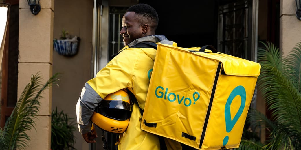 Glovo courier carrying a delivery bag for shopping orders connected to ChatGPT and Claude.