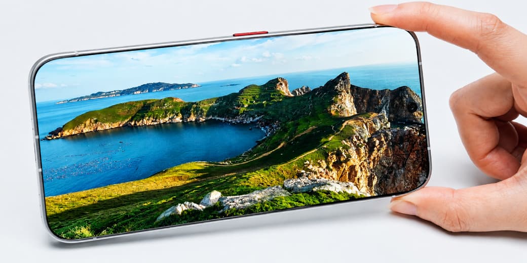TECNO 0mm-bezel concept phone held in landscape orientation with a coastal image filling the display.
